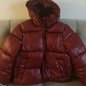 Vinröd pufferjacka - Säljer en snygg vinröd pufferjacka som är super populär och helt slutsåld!! Den är oversize, super varm och lite glansig som sista bilden😍😍nyskick, aldrig använt!!  Säljer eftersom den inte passade mig så bra