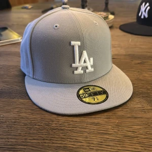 Keps från New era (fitted modell)  - Säljer en stilren grå keps från New Era. Kepsen är i storlek 7 3/8 och är aldrig använd. 