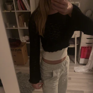 Svart croppad tröja - Säljer en svart croppad tröja med lång ärm. Perfekt för en avslappnad stil eller att matcha med ett vitt linne under. Tröjan är i bra skick och är i spets. Passar perfekt för en festlig look.🌟