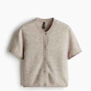 Beige kortärmad kofta  - Säljer en superfin beige kofta i ullblandning. Den har korta ärmar och knappar framtill, perfekt för lager på lager-stil. Passar både till vardags och lite finare tillfällen. Skön och stilren, ett måste i garderoben! 💫