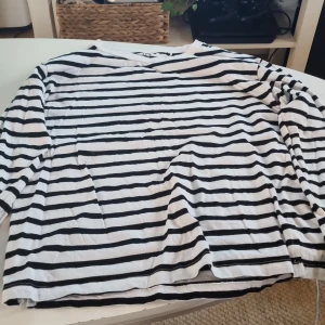 Randig tröja från 157 - Säljer en randig tröja från 157 i storlek XS. Den är vit med svarta ränder och har långa ärmar. Tillverkad i 100% bomull, vilket gör den superbekväm och perfekt för vardagsbruk. Passar bra till både jeans och kjol!