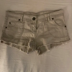 Beige shorts från Denim Co. - Säljer ett par snygga gråbeige shorts från Denim Co. i storlek 36, men skulle uppskatta de till en xs. De är Lågmidjade i jeansmaterial med fransiga kanter. I toppenskick utan några synliga deffekter!
