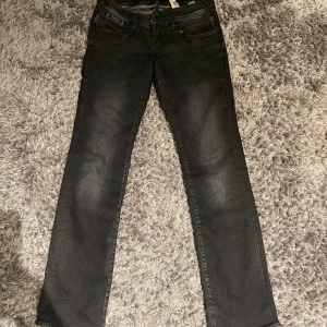 Svarta jeans från Herrlicher - Säljer ett par svarta/gråa lågmidjade jeans från Herrlicher i modellen Piper Slim. De är i bra skick och har en snygg, cool design, stretchiga i materialet. Nypris ca 1200kr
