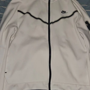 Nike tech vit - Säljer min vita nike tech hoodie eftersom att den inte används längre. Den är jätte skön och varm och passar till höst och vinter. Storlek är XL men passar L mer. Om man gillar baggy så passar det alla andra storlekar. Skriv till mig om du har frågor