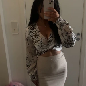 Leopardmönstrad blus med knyt - leopardmönstrad blus med knyt framtill. Blusen har långa ärmar och en djup v-ringning, vilket ger en stilfull look. Aldrig använd