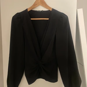 Svart blus Nelly  - En jätte fin svart blus från Nelly med detalj. Blusen är i kvalitativt och skönt material. Tröjan är i storlek xs och kan även bäras bak och fram så det blir öppet i ryggen. Säljs då den inte kommer till användning💞
