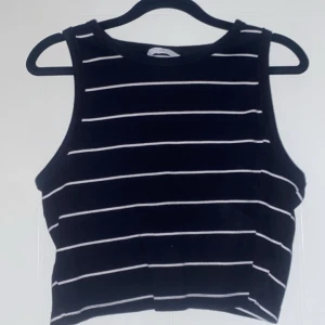 Svart och vit randig linnetopp - Snygg svart linnetopp med vita ränder. Använd fåtal gånger och i perfekt skick! Säljer pga att den inte kommer till användning. Väldigt stretchig så upplever att den är från S-L :)