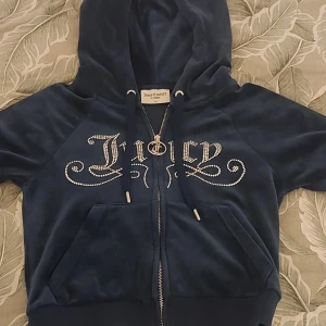 Mörkblå velour hoodie från Juicy Couture - Säljer en snygg mörkblå kofta från Juicy Couture med glittrande stenar med texten 'Juicy' på framsidan. Koftan har en dragkedja med ett Juicy Couture-hänge! Den är i väldigt bra skick, knappt använd. Skriv för mer detaljer/betalnings sätt! <3