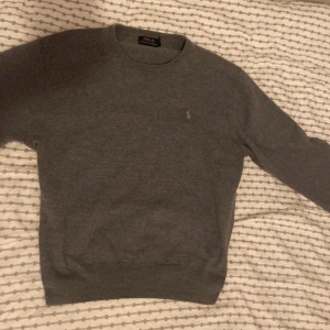 Grå tröja från Ralph Lauren - Säljer en stilren grå tröja från Ralph Lauren i mjukt ullmaterial. Perfekt för kyligare dagar. Inga defekter. Sitter typ som en S. 