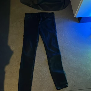 Svarta  jeans - Snygga svarta jeans med en klassisk straight passform. Perfekta för en avslappnad stil. De har en dragkedja och knappar framtill.