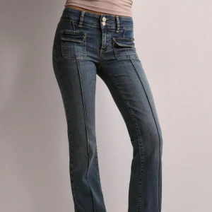 Blå bootcut jeans - Säljer mina ”low waist bootcut pocket jeans” med låg midja och dubbla knappar. De har framträdande sömmar och flera fickor fram och bak för en cool look. Dom är köpta för 700 kr men säljer dom för 300 kr 💓