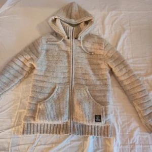 Stilren Cardigan med fordring  - Säljer en stilren tjock cardigan med i storlek M men passar även L. Passar perfekt till vintern men även kyligare vårdagar. Cardiganen är ifrån Shakaloha men säljs inte längre. Priset är ej hugget i sten 🙌