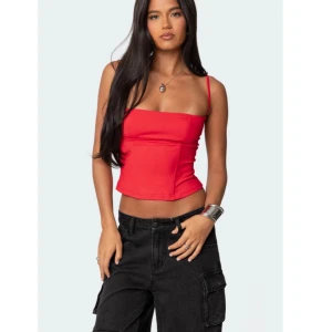 Röd ärmlös korsettopp - Snygg röd korsettopp med smala axelband och figurnära passform. Perfekt för en trendig look.
