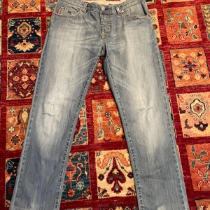 Ljusa jeans med slitningar tramarossa  - Snygga ljusa jeans från tramarossa med slitningar på framsidan för en trendig look. Klassisk femficksdesign och knappgylf. Perfekta för en avslappnad stil. De har gåt sönder på tre ställen.Om du har några frågor fråga på mvh Theodor 