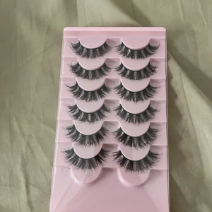 Svarta lösögonfransar i set - Säljer ett set med dramatiska svarta lösögonfransar. Perfekta för att ge en intensiv look med volym och längd. Kommer i en praktisk rosa förpackning med flera par för olika tillfällen. Fransarna innehåller 6 st fransar då en rad har använts,