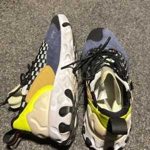 Färgglada sneakers med rutigt mönster - Snygga och unika sneakers med en mix av färger som blå, gul och svart. Skorna har ett iögonfallande rutigt mönster och snörning. Perfekta för dig som vill sticka ut!