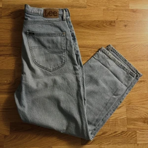 Grå jeans från Lee - Snygga grå jeans från Lee i modellen Asher. De har en klassisk femficksdesign och är tillverkade i slitstarkt denim. Perfekta för en avslappnad stil.