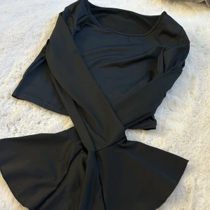 Svart långärmad tröja - Elegant svart långärmad tröja med en enkel och stilren design. Perfekt för olika tillfällen med sin klassiska look.