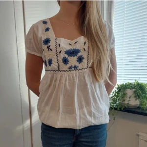 Supersöt vit blus!! - Säljer denna jättefina vita blusen med fina broderade detaljer!!😍 I otroligt fint skick och använd fåtal gånger. I storlek L men skulle säga att den passar för storlek XS- M också🥰