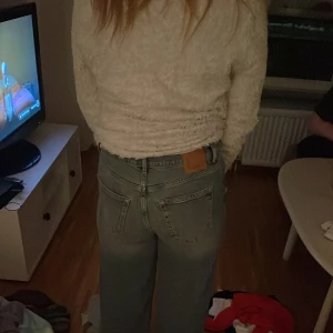 Blå jeans med hög midja - Snygga blå jeans med hög midja och en avslappnad passform. De har klassiska femficksdetaljer och en rak siluett som ger en tidlös look. Perfekta för en casual stil.