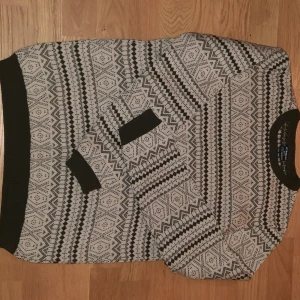 Mönstrad tjocktröja från LC Waikiki - Säljer denna snygga jul/vinter mönstrade tröjan från LC Waikiki i mörkgrönt och vitt. Tröjan har ett geometriskt mönster ribbade kanter vid hals, ärmslut och nederkant. Få gånger använd och har inga defekter.