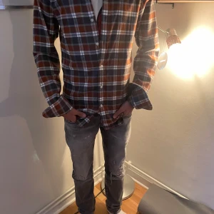 Rutig skjorta från John Henric - Säljer en snygg rutig skjorta från John Henric i brunt, grått och vitt. Skjortan har långa ärmar och knappar fram. Perfekt för höst och vinter, och den är i mycket bra skick. Passar både till vardags och lite finare tillfällen. Skön och stilren design!