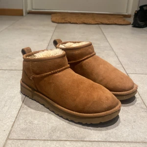 Bruna boots från UGG - Säljer ett par bruna boots från UGG i mocka med mjukt foder. Perfekta för kyliga dagar med sin varma insida och klassiska design.