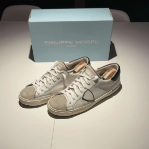 Philippe model, vita - Tjena! 👋Nu säljer jag ett par snygga vita skor från Philippe Model med grå detaljer och snörning. Skorna är riktigt feta och passar till allt. Skick, 8/10, har en slitning på höger sko-bild 4| storlek 43 | Hör av er vid minsta fundering eller prisförslag. 😊