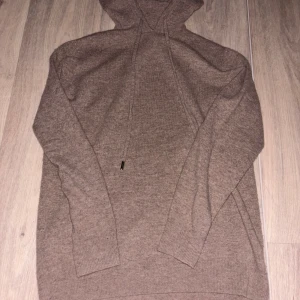 Beige stickad hoodie - Mysig beige stickad hoodie med långa ärmar och justerbar huva. Perfekt för kyliga dagar och ger en avslappnad stil.