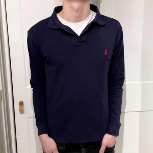 Ralph Lauren pikétröja  - Långärmad Ralph Lauren piké i färgen blå. Inga defekter på tröjan. Size M (slim fit) modellen är 177cm. Hör av dig vid funderingar!