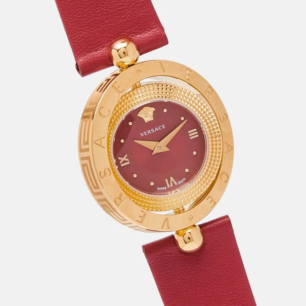 Elegant röd klocka från Versace med ett guldigt boett och matchande röd urtavla. Klockan har en stilren design med romerska siffror och ett rött läderarmband. Perfekt för att ge en lyxig touch till din stil.. Asusteet.