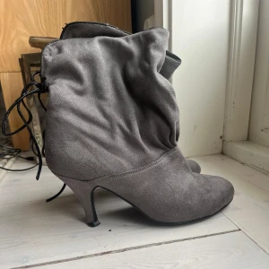 Gråa stövlar / stövletter - Säljer dessa sjukt snygga stövletter då dom tyvärr är lite för stora för mig (bär vanligtvis 39). Enda defekten är att gummit under ena klacken är trasigt vilket går att fixa med lim alternativt hos en skomakare. Annars är dom i bra kvalitet!😍