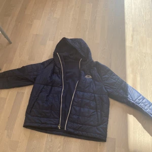 Blå nike dunjacka - En fin mörkblå dunjacka ifrån Nike. Storlek XL och har två sidfickor med en knapp man knäpper och mjukt material på insidan