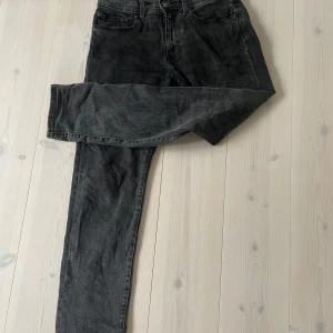 Svarta jeans - Säljer ett par svarta jeans i bra skick från Levis. De har en klassisk design med fem fickor och dragkedja. Perfekta för vardagsbruk eller en utekväll. Passar till det mesta och är superbekväma! Knappt använda, 1099 nypris. W32 L32. Modell 502