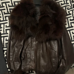 Läderjacka med äkta päls - Äkta läderjacka mörkbrun med äkta minkpäls runt krage och på armarna. Nypris: 4000kr Mycket bra skick