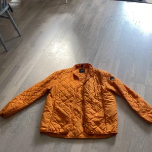 Orange peak performance jacka  - En orange peak performance jacka från Åre med två sidfickor och en innerficka med dragkedja.