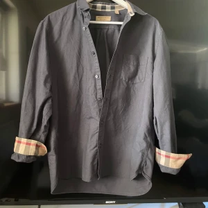 Burberry skjorta - En riktigt snygg burberry skjorta, har ett litet hål vid höger axeln, se bild 3. Förutom det är den i riktigt bra skick🙌🏻