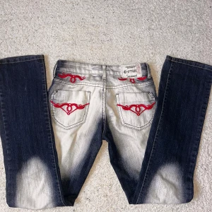 Unika jeans med röda broderier - Ett par såå coola jeans med unika röda broderier på bakfickorna och framfickorna som tyvär inte kommer till användning. Byxan är omsydda till en mindre storlek av förra ägaren från st 38 till 34 skulle jag säga. Gylfknappen sitter lite löst men går fortfarande att använda🤗 hör av er vid minsta fråga💕