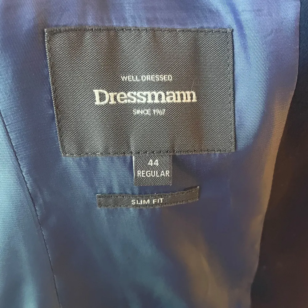 Säljer en stilren blå kavaj från Dressmann i storlek 44, vilket motsvarar ungefär small. Kavajen har en slim fit passform och är perfekt för både fest och formella tillfällen. Den har två knappar framtill och är i stort sett nyskick. Hör av dig vid några eventuella frågor :). Kostymer.