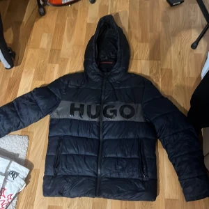 Hugo jacka - Äkta hugo jacka köpt från room 1006. Har tyvärr inget kvitto. Skick 9/10, 2 små brännhål vid vänstra sidan. Storleken är S men passar som M