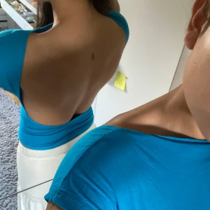 Blå tight rygglös topp - Säljer en snygg blå tight rygglös topp med korta ärmar. Perfekt för sommardagar eller en utekväll. Toppen är i ett mjukt och stretchigt material som sitter skönt mot kroppen. Passar bra till både kjol och jeans!