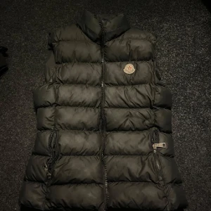 Moncler väst  - Moncler väst strl 2 men passar mig som är S, defekter på ryggen annars bra skick