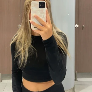 Långärmad topp  - Svart kort långärmad topp från Nelly, använd men i bra skick.