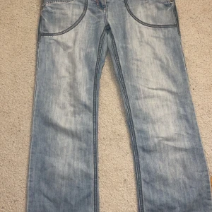 Lågmidjade jeans  - Jeans i storlek M. Köpta secondhand men är från märket BOYFIT DENIM. De är i bra skick men har två minde fläcker på baksidan. Dem e blåa med rosa detaljer. Pris kan diskuteras