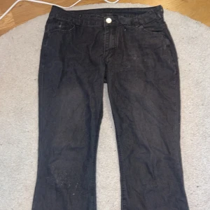 Svarta lågmidjade bootcut jeans  - Svarta lågmidjade bootcut jeans från amazon. Knappen sitter lite löst och dom är lite rispade på det högra knät men annars är de i bra skick. De är i storlek L. Pris kan diskuteras 
