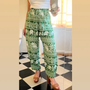 Gröna haremsbyxor s/m - Snygga byxor med ett mönster av elefanter och paisley. Byxorna har en elastisk midja och är lösa i benen. De är perfekta för en avslappnad look. Maximalt midjemått 36 cm, se bilderna  Knappt använda, i mycket bra skick.