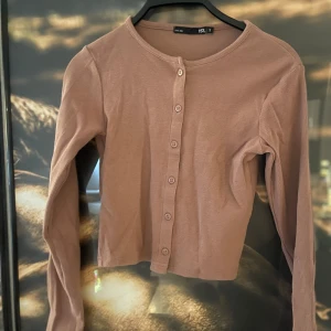 Beige ribbad kofta från 157 - Säljer en snygg beige ribbad kofta från 157 i storlek S. Den har långa ärmar och knappar framtill, perfekt för lager-på-lager under hösten. Koftan är i bra skick och supermjuk. Passar både till vardags och lite finare tillfällen. 🌟