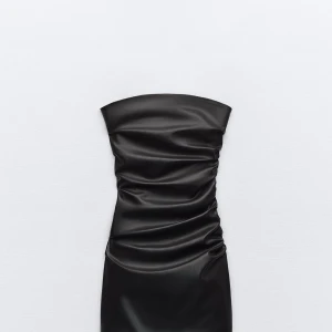 Svart axelbandslös klänning - Snygg svart axelbandslös klänning i skinnimitation. Den har en tight passform med rynkade detaljer som ger en cool look. Perfekt för en utekväll eller fest! 🖤