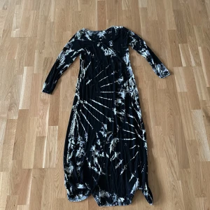 Långklänning - Långklänning i coolt mönster, svart som bas med vita och bruna detaljer.