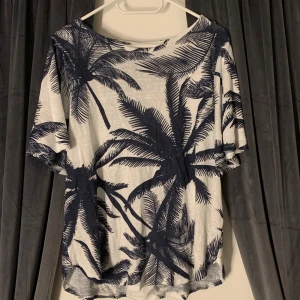 Semester tshirt med trumpetärm - En fin semester-tshirt med kortärmad trumpetärm. Tunnt stickad. Fint skick!